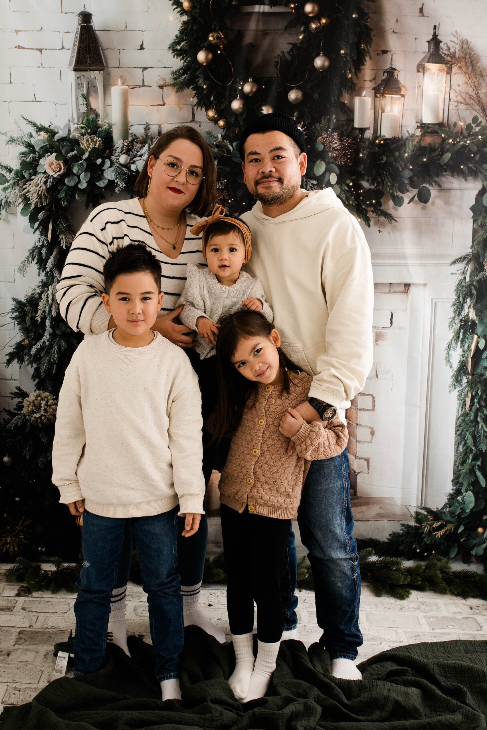 Eine Familie sitzt lachend in einem weihnachtlich dekorierten Studio in Rodgau, fotografiert von Julia Pitz.