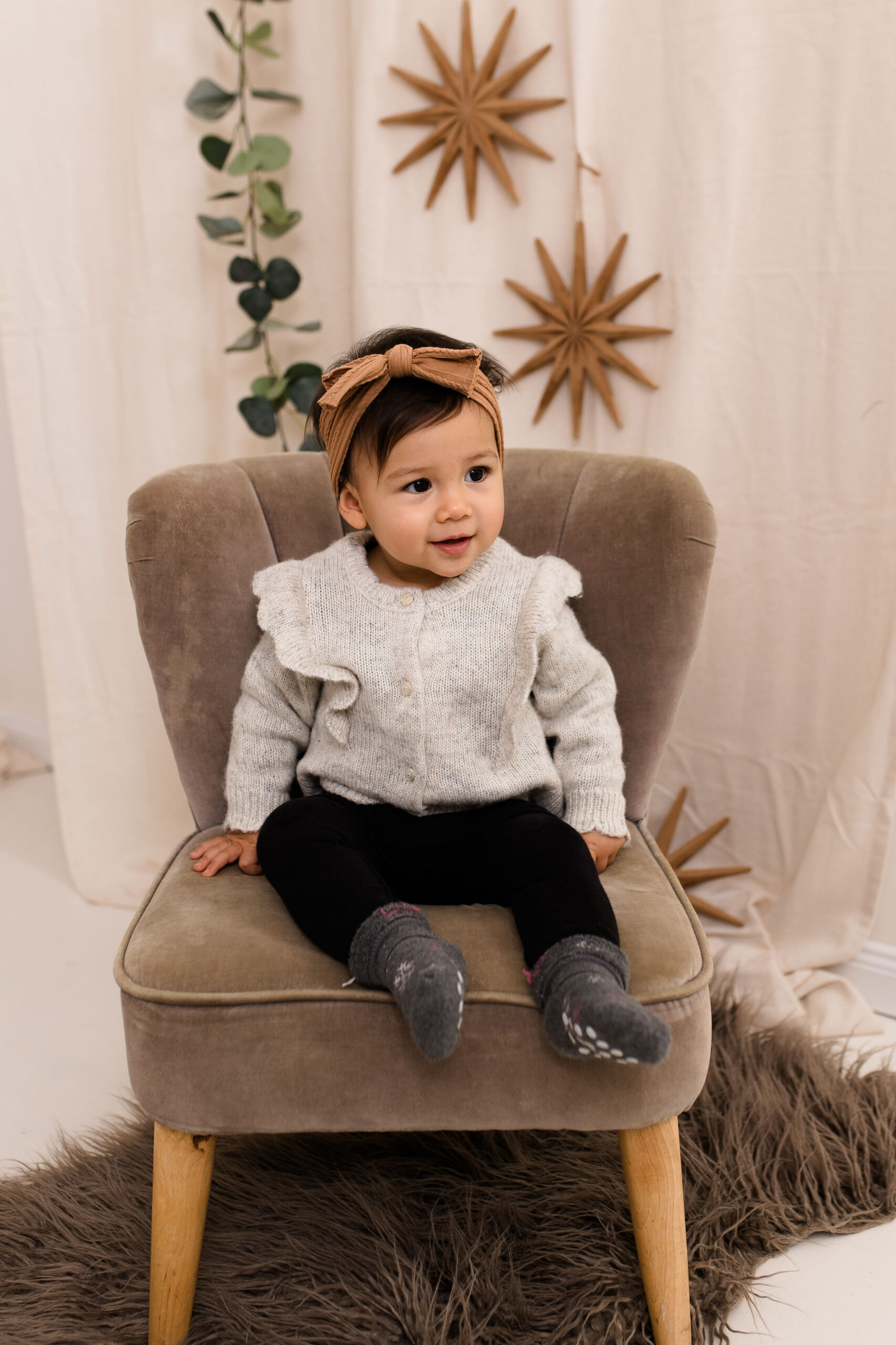 Eine Familie sitzt lachend in einem weihnachtlich dekorierten Studio in Rodgau, fotografiert von Julia Pitz.